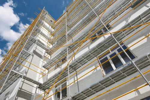 Immagine di un ponteggio allarmato con una cupola di sicurezza in primo piano, utilizzato per la manutenzione di edifici e strutture.