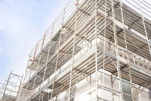 Immagine di un ponteggio in fase di ristrutturazione su un edificio di grandi dimensioni, utilizzando materiali sostenibili.