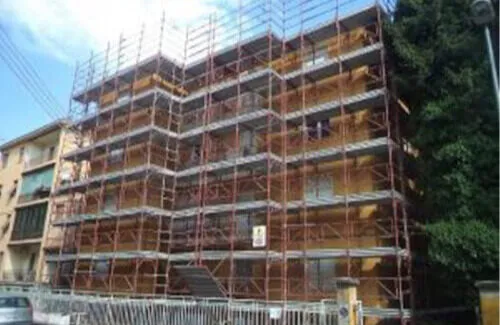 Immagine di un ponteggio in manutenzione, con una squadra di lavoratori che eseguono riparazioni e controlli di sicurezza.
